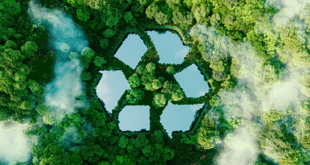 Forêt vue du dessus avec un étang en forme de symbole de recyclage